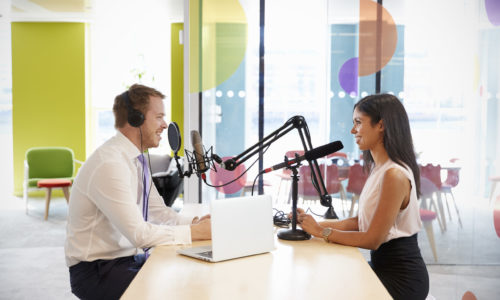 Young man interviewing a woman for a podcast Young man interviewing a woman for a podcast