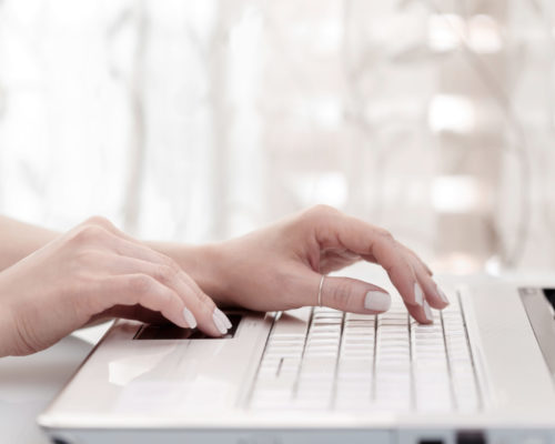 female hands using modern computer Close up of female hands using modern computer, high key. Blogger concept